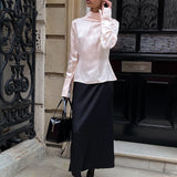 Blusa aderente con collo alto in raso a righe e cintura annodata in vita