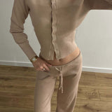 Completo due pezzi sexy in maglia aderente con bottoni, maniche lunghe e vita bassa