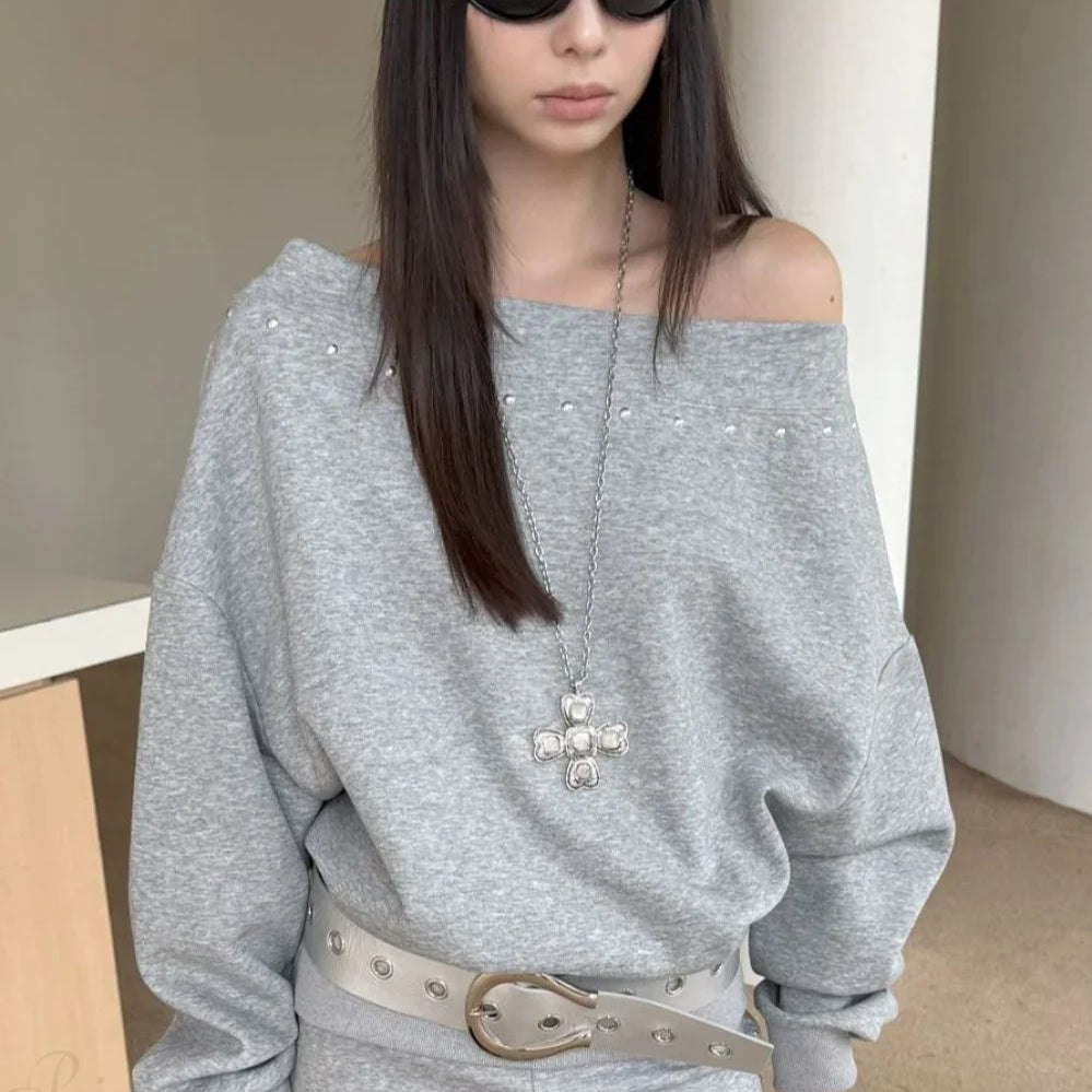 Felpa ampia con borchie e spalle scoperte asimmetriche