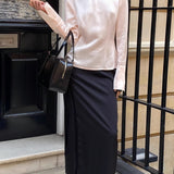 Blusa aderente con collo alto in raso a righe e cintura annodata in vita