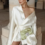 Mini abito a trapezio con scollo a V e maniche lunghe in raso color champagne con cintura annodata in vita