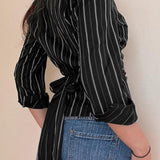 Camicetta a maniche lunghe con colletto a righe intrecciate e cintura annodata in vita