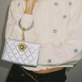 Cardigan corto in maglia con bottoni a rombo e ricami floreali a girocollo