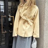 Cappotto di media lunghezza con cintura in vita, tinta unita e minimalista