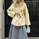 Cappotto di media lunghezza con cintura in vita, tinta unita e minimalista