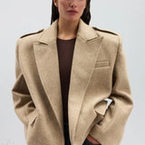 Blazer di lana con spalline e revers a lancia oversize